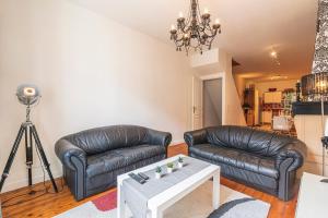 a living room with two leather couches and a table at Bar à Bulles - Ancien Comptoir Transformé in Reims