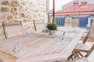 a wooden table with glasses on top of a balcony at Bar à Bulles - Ancien Comptoir Transformé in Reims