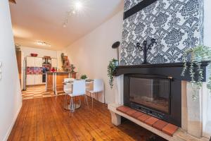 a living room with a fireplace and a dining room at Bar à Bulles - Ancien Comptoir Transformé in Reims