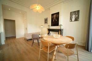 a living room with a table and chairs and a fireplace at Noble Nest - Downtown in Brussels