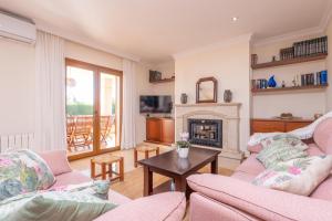 a living room with two couches and a fireplace at Can Albons in Portocolom