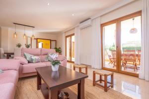a living room with a pink couch and a table at Can Albons in Portocolom