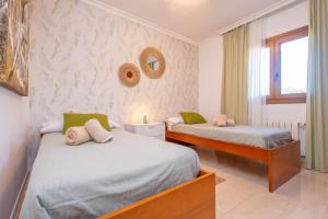 a bedroom with two beds and a window at Can Albons in Portocolom +50 photos