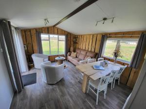a living room with a table and chairs and a couch at Hoeve Twente - De Buizerd in Heythuysen