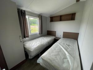 two beds in a small room with a window at Hoeve Twente - De Buizerd in Heythuysen