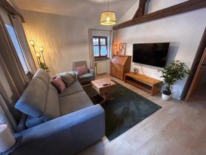 a living room with a couch and a flat screen tv at Ferienwohnung Stüberl in Oberammergau
