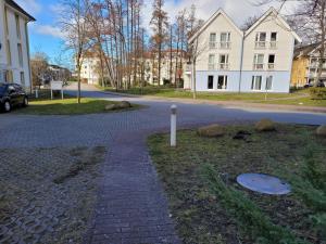 a cobblestone street in front of a white building at Ferienwohnung LEE 8 in Graal-Müritz