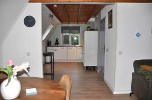 a kitchen with a table and a refrigerator at Torenvalk I Genieten nabij Bos in Zwiggelte