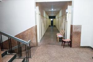 a hallway with two chairs and a stair case at Hotel Rainbow near Victoria Hospital City Market in Bengaluru