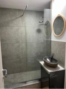 a bathroom with a sink and a glass shower at Ella Apart Hotel in Constanţa