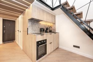 une cuisine avec des placards en bois et un escalier dans l'établissement Cozy loft in Vilnius city center, à Vilnius