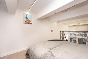 une chambre avec un lit et un tableau au mur dans l'établissement Cozy loft in Vilnius city center, à Vilnius