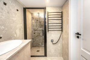 une salle de bain avec douche et lavabo dans l'établissement Cozy loft in Vilnius city center, à Vilnius