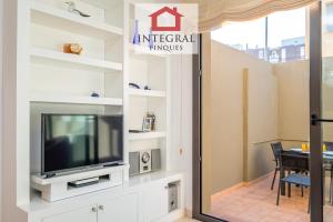 a living room with a tv and a dining room at Ca la Blava Palamós in Palamós
