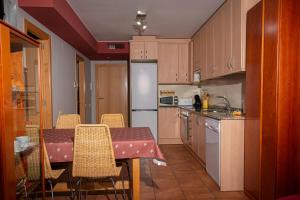 a kitchen with a table and chairs and a refrigerator at Casa Baja in Valderrobres