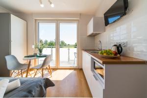 a kitchen with a sink and a table with a bowl of fruit at Verde House in Karwia
