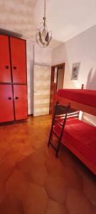 1 dormitorio con cama roja y vestidor en Trilocale 200m dal mare - Il Faro Blu, en Martinsicuro