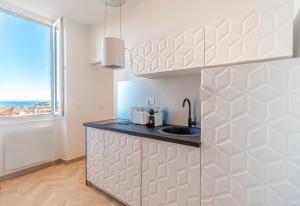 a kitchen with a sink and a window at T2 Town Center, Casino in Beausoleil