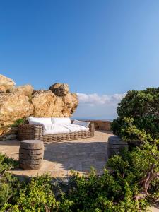 un sofá de ratán sentado en un patio cerca del océano en Villa Tavani Agios Ioannis Mykonos, en Agios Ioannis Mykonos 49 fotos más