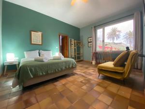 a bedroom with a bed and a chair and a window at Porto Santo Destination in Porto Santo