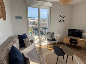 a living room with a couch and a television at Le Sémaphore Une Escale poétique au fil de l'eau et de l'histoire in Brest