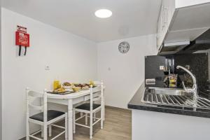 a kitchen with a table with chairs and a sink at Seaside Charm I in Câmara de Lobos