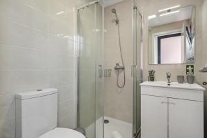 a bathroom with a shower and a toilet and a sink at Seaside Charm I in Câmara de Lobos +11 photos