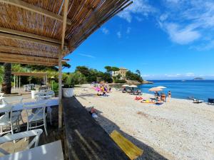a group of people on a beach near the water at La Pergola al Cavo 107 in Cavo