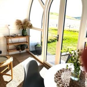 a living room with a large window with a cat at Heather Pod in Perth +1 photo