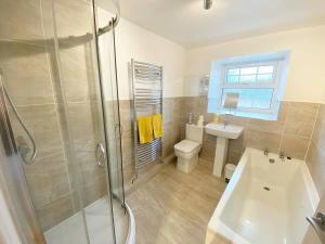 un bagno con doccia, WC e lavandino di 43 Heol Maelor- A Homely Cottage in Wrexham, North Wales a Coedpoeth
