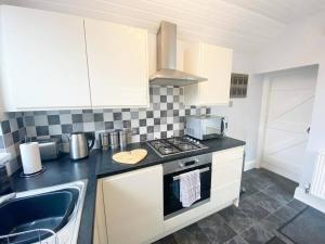 una cucina con fornello forno superiore accanto a un lavandino di 43 Heol Maelor- A Homely Cottage in Wrexham, North Wales a Coedpoeth Altre 18 foto