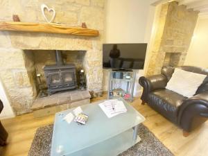 un soggiorno con divano e camino di 43 Heol Maelor- A Homely Cottage in Wrexham, North Wales a Coedpoeth