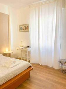 een slaapkamer met een bed en een wit gordijn bij La Casetta in Le Grazie