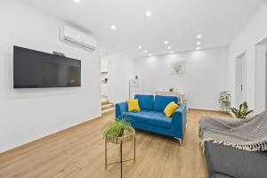 a living room with a blue couch and a tv at Old Tower Center Apartment 2 in Pula