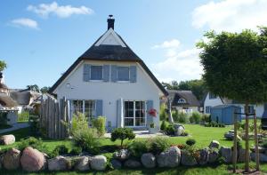 a white house with a pitched roof at Ferienhaus Poolhaus in Glowe