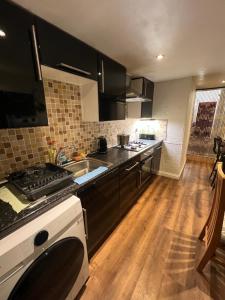 una cocina con fregadero y estufa horno superior en room near Luton center, en Luton 9 fotos más