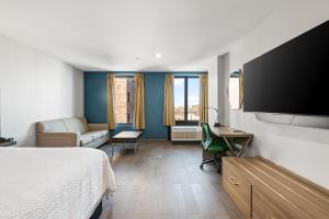 a bedroom with a bed and a flat screen tv at Holiday Inn Express & Suites Bronx - Zoo Area by IHG in Bronx +36 photos