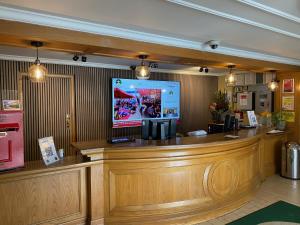 a bar in a restaurant with a tv above it at Airport Inn Manchester in Wilmslow