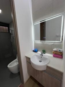 a bathroom with a sink and a toilet and a mirror at Jin Lin Homestay 1 in Sibu