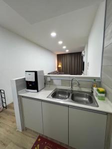 a kitchen with a sink and a microwave at Jin Lin Homestay 1 in Sibu