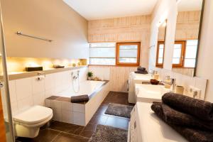 a bathroom with a tub and a toilet and a sink at Designferienhaus Altenmarkt Zauchensee in Altenmarkt im Pongau +47 photos