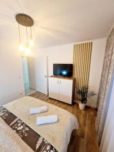 a bedroom with a bed with two towels on it at Dream ApartHotel in Turda +13 photos
