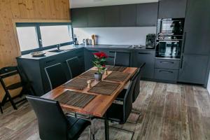 a kitchen with a wooden table with chairs and a tableasteryasteryasteryasteryastery at Rezidence U Hájenky 434 in Lipno nad Vltavou