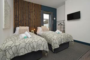 a bedroom with two beds and a flat screen tv at Stay at Shobnall Road Rooms and Studios Burton in Burton upon Trent +76 photos
