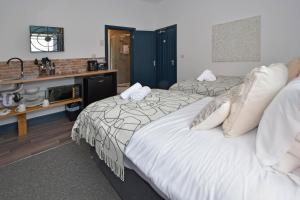 a bedroom with two beds and a desk with a microwave at Stay at Shobnall Road Rooms and Studios Burton in Burton upon Trent