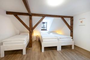 two beds in a room with wooden beams at Avama - apartmány Srní in Srní