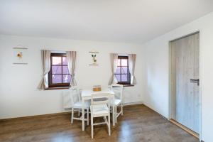 a dining room with a white table and chairs at Avama - apartmány Srní in Srní +44 photos