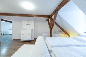 a attic bedroom with two beds and a dresser at Avama - apartmány Srní in Srní