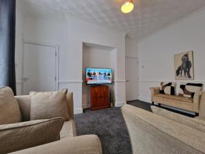 a living room with two couches and a flat screen tv at Nice Living Serviced Accommodations Leicester in Leicester