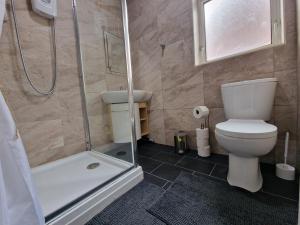 a bathroom with a shower and a toilet and a sink at Nice Living Serviced Accommodations Leicester in Leicester